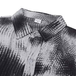 Detail shot of the collar and abstract grayscale pattern on a men's beach shirt.