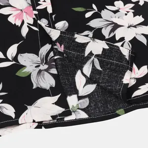 Nahaufnahme von einem schwarzen Hawaii-Blumenhemd mit Tropenprint und weißen Knöpfen