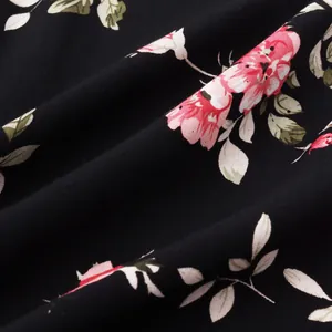 Makroaufnahme von schwarzem Hawaii-Hemd-Stoff mit rosa Blumenmuster