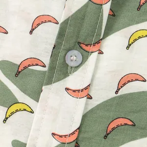 Primo piano di camicia floreale da uomo con motivo a banane e foglie e dettaglio bottone.