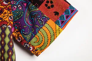 Detailansicht des Ärmels eines farbenfrohen Patchwork-Hemdes mit Blumenmuster.