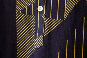 Detailed macro shot of the linen fabric texture and yellow pattern on a men's shirt