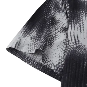 Close-up detail of Hawaiian shirt sleeve showing abstract black and white print and stitching