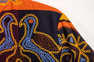 Gedetailleerd macrozicht op de levendige etnische zwanenprint op een herenzomershirt
