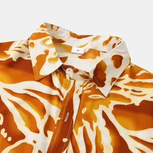 Close-up of men's summer short sleeve floral shirt collar with bold orange leaf print
