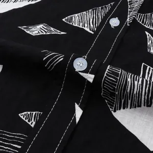 Close-up of black Hawaiian shirt fabric with white geometric prints and buttons