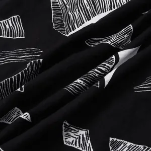 Close-up view of black and white geometric pattern on breathable beach shirt fabric.
