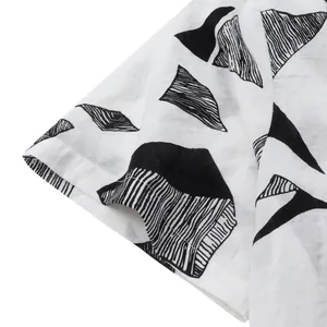 Close-up of short sleeve cuff on a men's white Hawaiian shirt with black geometric patterns