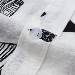 Close-up detail of button and leaf pattern on casual men's cotton linen beach shirt