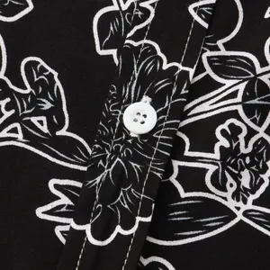 Close-up of white floral print and button detail on a black casual men's shirt