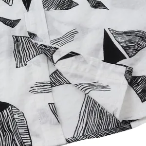 Close-up of Hawaiian beach shirt fabric showing black geometric patterns and seams