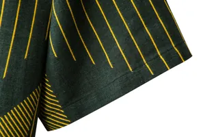 Close-up detail of a men's casual linen shirt sleeve featuring yellow vertical stripes