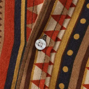Close-up macro view of the ethnic pattern fabric and white button on a men's shirt