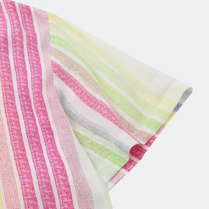 Détail montrant l'imprimé à rayures colorées et la texture du tissu d'une chemise de plage
