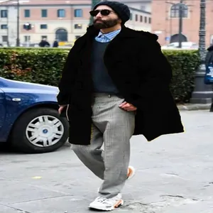 Detalle de hombre con chaqueta de lana negra con capucha en un entorno urbano elegante