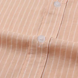 Close-up macro shot showing fabric texture and clear buttons on a peach striped shirt