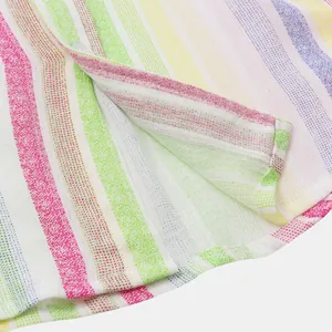 Gros plan du tissu à rayures arc-en-ciel et de l'ourlet d'une chemise de plage pour homme
