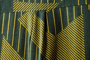 Macro view of green cotton-linen blend fabric with yellow geometric stripe pattern