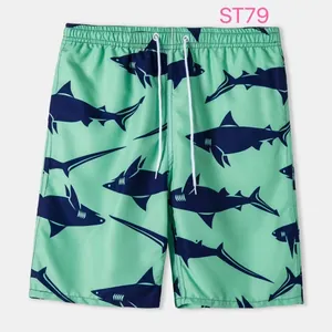 Detailed view of men's green swim trunks featuring navy blue shark pattern print