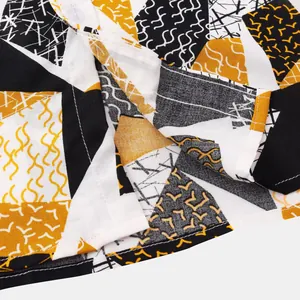 Detailed view of abstract geometric pattern and hem stitching on men's short sleeve shirt
