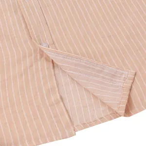 Close-up detail of orange and white striped men's casual beach shirt showing hem and button placket