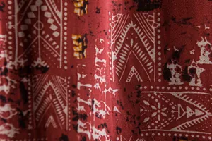 Close-up of ethnic geometric print on red breathable fabric for men's beach shirt