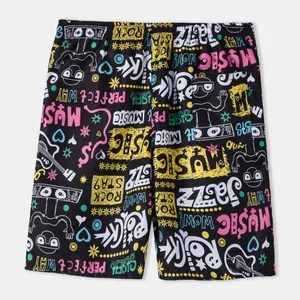 Detailed view of men's beach shorts with colorful graffiti music-themed patterns