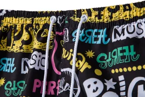 Close-up of men's beach shorts featuring colorful graffiti print and drawstring