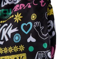 Detail view showing high-quality stitching and vibrant graffiti print on black men's beach shorts.