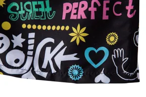 Detailed view of colorful graffiti print on black men's beach shorts fabric.