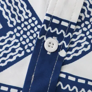 Close-up of blue ethnic geometric print and white button on a casual men's shirt