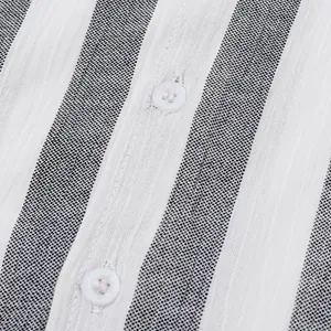 Gros plan d'une chemise pour homme à rayures noires et blanches, texture lin et boutons