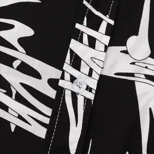 Close-up detail of black and white abstract print men's shirt with white button