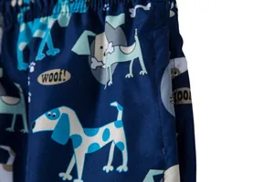 Close-up detail of navy blue men's beach shorts with cute cartoon dog print pattern