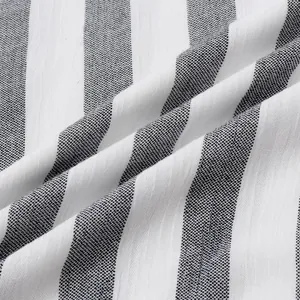 Gros plan sur un tissu à rayures verticales noires et blanches, texture coton-lin.