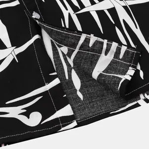 Macro detail of men's tropical leaf print shirt showing fabric texture and stitching