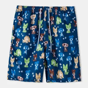 Detailed view of the vibrant cartoon dog pattern on these navy blue men's swim trunks.
