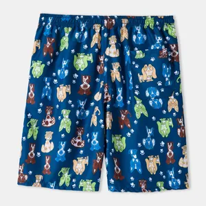 Detailed view of men's swim trunks with vibrant cartoon dog print and back pocket.