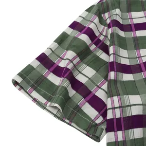 Detailed view of fabric texture and stitching on a men's green and purple plaid shirt