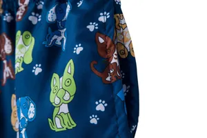 Detailed view of mens beach shorts fabric with colorful cartoon dog and paw prints