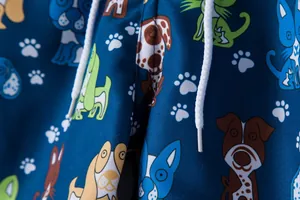 Close-up of men's beach shorts featuring colorful cartoon dog patterns and white drawstring