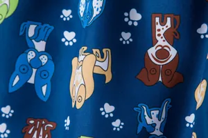 Detailed macro shot of blue swimwear fabric featuring playful cartoon dog patterns