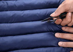 Close-up of durable navy blue quilted fabric on men's winter padded jacket.