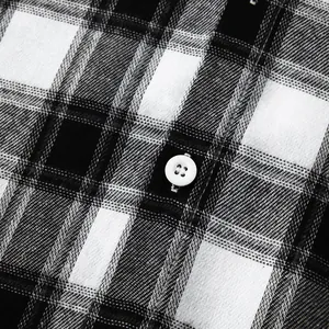 Detailed macro view of black and white plaid fabric texture and white button on men's shirt