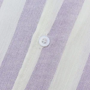 Gros plan sur le tissu à rayures violettes et blanches et le bouton d'une chemise d'été
