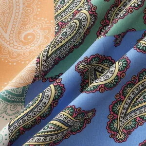 Detailed macro view showing the vibrant paisley print texture of a men's summer shirt
