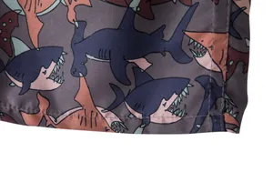 Close-up macro detail of cartoon shark pattern on quick-dry beach shorts fabric
