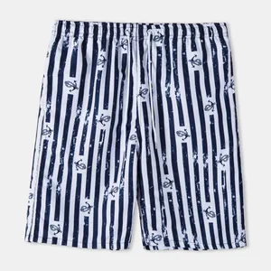 Men's navy blue and white vertical striped swim trunks with small anchor pattern print.