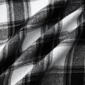 Detailed macro view showing the black and white plaid fabric texture of a men's shirt