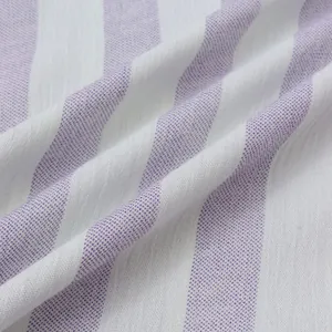 Gros plan sur un tissu léger à rayures violettes et blanches pour chemise de plage